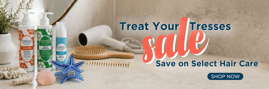 Promotional banner for hair care products showing several bottles and a hair dryer on a bathroom counter, with text reading 'Treat Your Tresses sale Save on Select Hair Care' and a 'SHOP NOW' button.